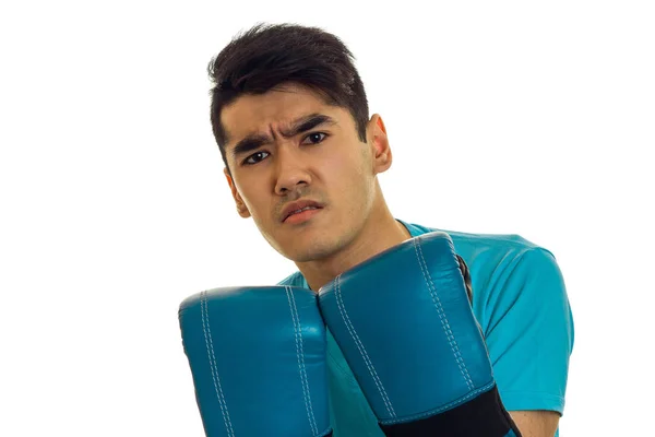 Портрет розлюченого спортсмена з темним волоссям, що практикує бокс у синіх рукавичках та уніформі ізольовані на білому тлі — стокове фото
