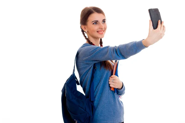 Joven chica-adolescente con una cartera en el hombro hace que el teléfono selfi — Foto de Stock