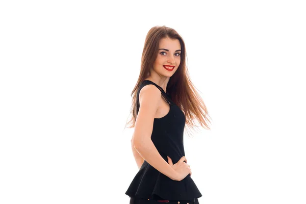 Gyönyörű lány, fekete ruhában érdemes oldalra fordult, hogy a kamera mosolyogva, és tartja a kezét oldalán — Stock Fotó