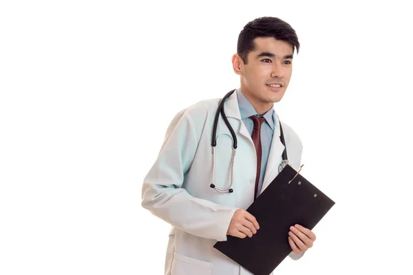 Jovem morena bonita médico masculino em uniforme com estetoscópio em seu pescoço posando e olhando para longe isolado no fundo branco — Fotografia de Stock