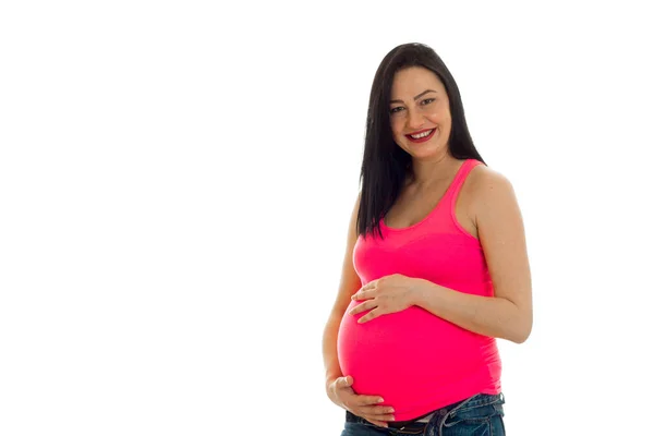 Joven embarazada morena chica tocando su vientre aislado en blanco fondo — Foto de Stock