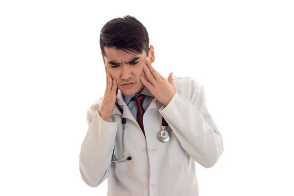 Молодий лікар у білій лабораторній шубці тримає голову — стокове фото