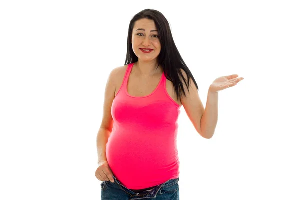 Jovem sorrindo mulher grávida em uma brilhante t-shirt levantada mão — Fotografia de Stock