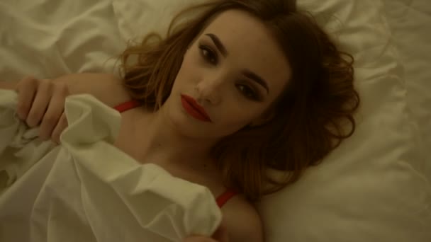 Retrato de bonita loira em lingerie vermelha com maquiagem na cama branca — Vídeo de Stock