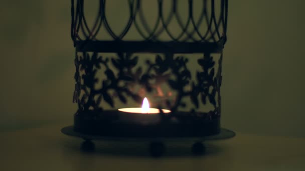 Свеча горит в красивом железном подсвечнике — стоковое видео