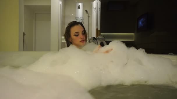 Charmerande ung kvinna badar i badtunnan med skum — Stockvideo