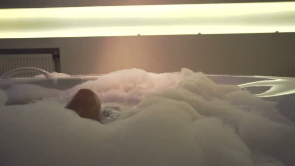 Сексуальные женские ноги в горячей ванне с пеной дома — стоковое видео