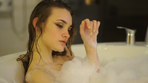 年轻漂亮的女人洗澡和轻松的在热水浴缸与泡沫 — 图库视频影像
