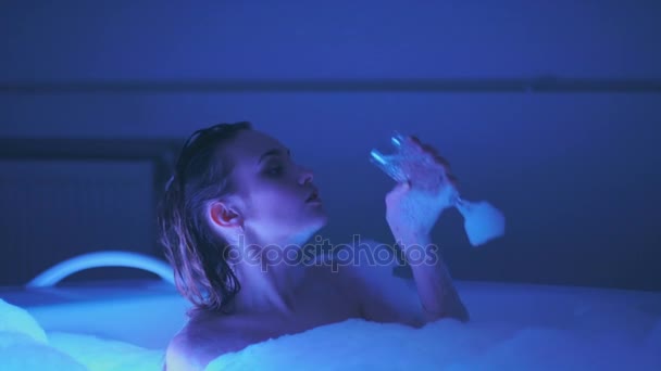 Adorabil femeie tânără baie și relaxare cu pahar de șampanie în cada cu spumă — Videoclip de stoc