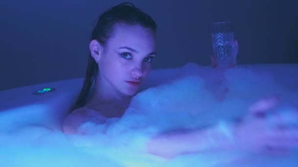 Sensuele jongedame Baden en ontspannen met een glas champagne in de hot tub met schuim — Stockvideo