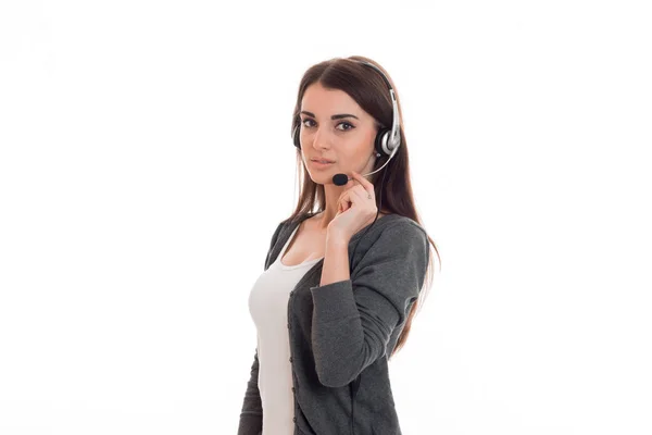 Krásná mladá dívka v sluchátka a šedé sako podívá do kamery a drží mikrofon ruční — Stock fotografie