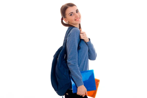 Милая девочка-подросток с косичками стоит сбоку и держит портфель — стоковое фото