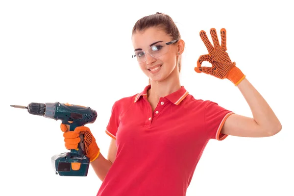 Niña sosteniendo un taladro para la reparación de un apartamento y muestra el gesto de la mano — Foto de Stock