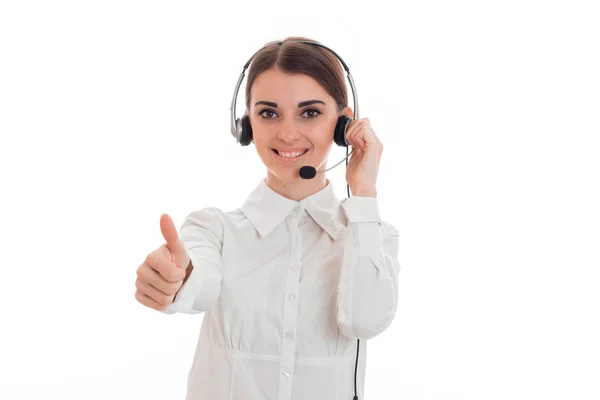 Krásná mladá brunetka obchodních žena s sluchátka a mikrofon ukazující palec nahoru a usmívá izolovaná na bílém pozadí — Stock fotografie