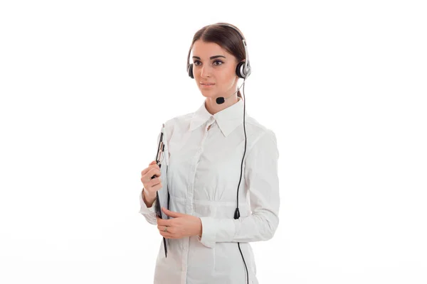 Hermosa joven morena mujer de negocios con auriculares y micrófono posando aislado sobre fondo blanco — Foto de Stock