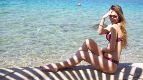 Blond smal lady solbad på sea beach — Stockvideo