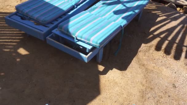 Tumbonas de arena y playa con bungalows cerca del mar — Vídeos de Stock