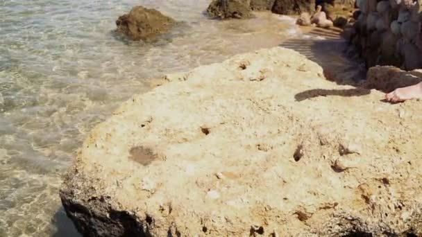 Girl walking on the rock in the sea — Stock Video