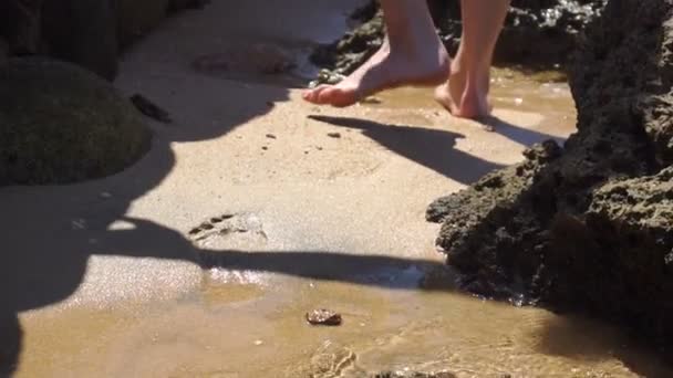 Close up van meisje wandelingen aan de kust en de golven zijn rollen op haar voeten — Stockvideo