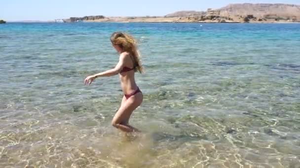 Heureux jeune fille mince en maillot de bain tournant autour de la mer heure d'été — Video