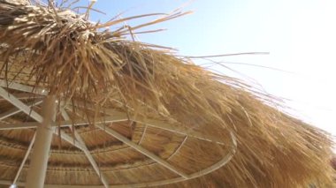 parlak güneşli bir günde saman güneş şemsiyesi