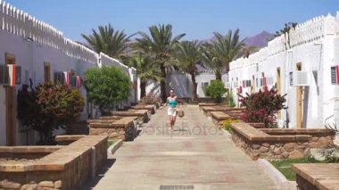 Ağır çekimde çalıştıran ve parlak güneşli bir günde kameraya gülümseyen tatlı genç kız