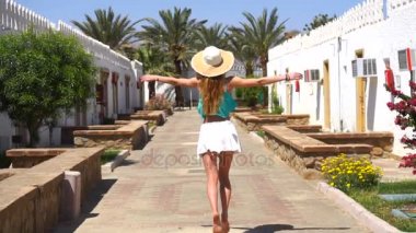 genç kız etek ileriye ellerini iki tarafta yayılan çalışır ve o ağır çekimde şapka kafası düşer