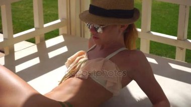 seksi genç kız bir şapka ve güneş gözlüğü Tan güneşin altında