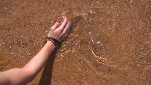 Una ragazza tiene la mano di acqua di mare pulita al rallentatore — Video Stock