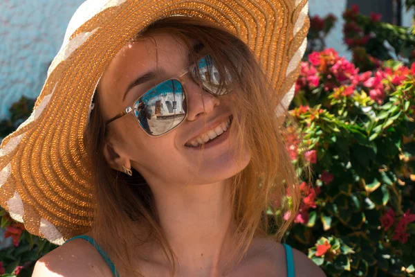 Signora in occhiali da sole a specchio e cappello di paglia sorridente sulla macchina fotografica all'aperto — Foto Stock