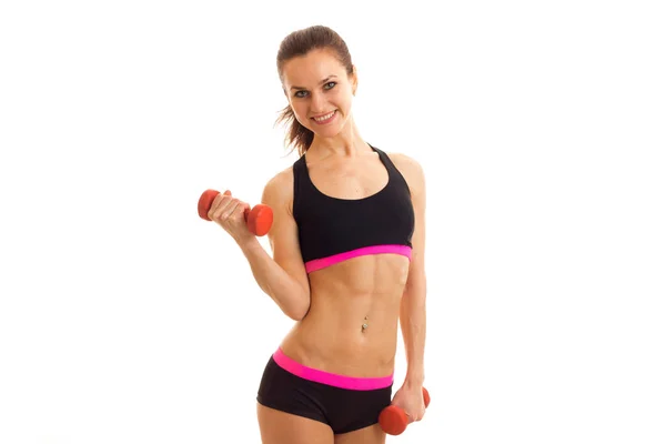 Athletic young girl at the top holding a dumbbell and smiling — Stock Photo, Image