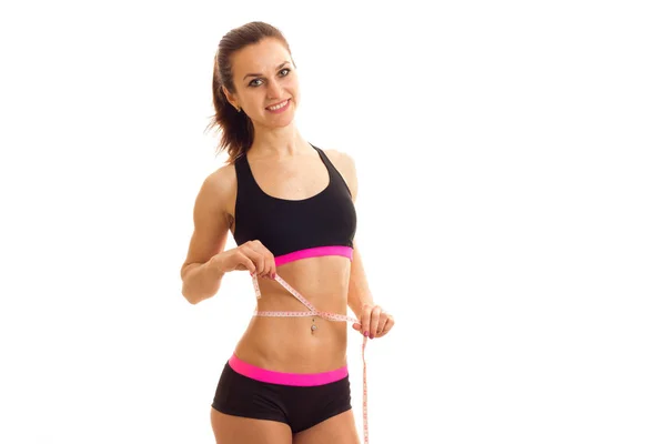 Athletic young girl with elastic waist measuring tape measures out belly — Stock Photo, Image