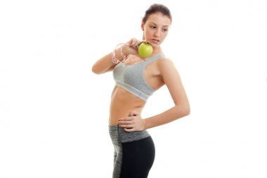 İnce genç kız aşağı yana görünüyor ve elinde tutan Apple duruyor