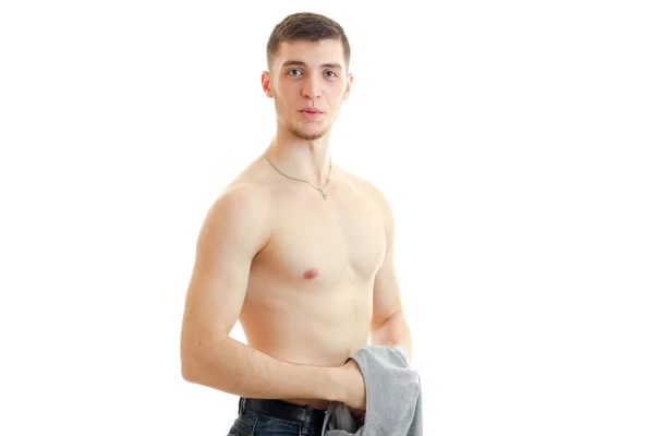 Young guy with a nice body looks into the camera and holds Mike Royalty Free Stock Images