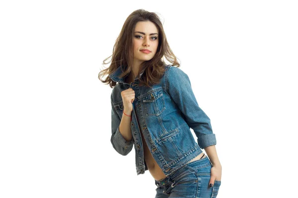 Affascinante bruna posa sulla macchina fotografica appoggiata alla giacca jeans — Foto Stock