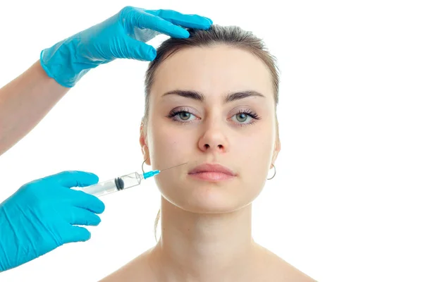 Kosmetolog i blå handskar gör ansiktsbehandling injektioner på en ung kvinna — Stockfoto