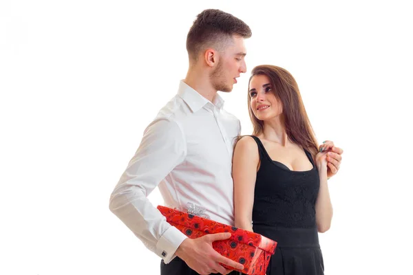 Молодой высокий парень в белой рубашке принес девушке красный подарочный коробок — стоковое фото