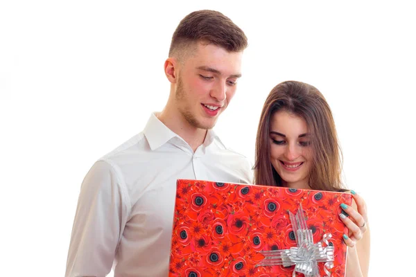 En ung flicka ser ut på den stora röda rutan på den gåva som förde kille och leende — Stockfoto