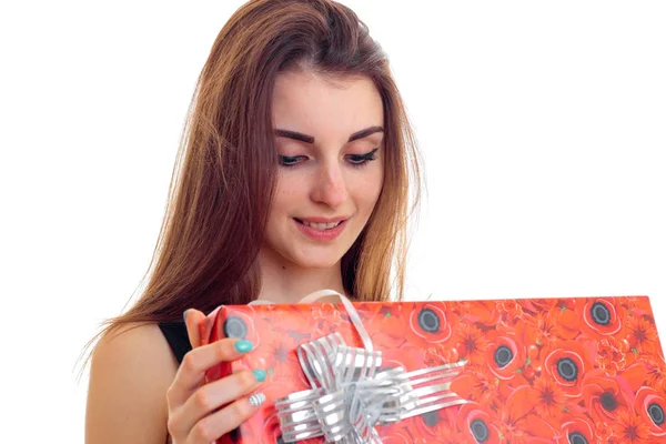 Jovencita sosteniendo un Giftwrap rojo y sonriendo aislado sobre fondo blanco — Foto de Stock