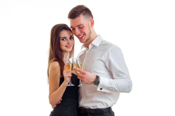 Jovem cara amoroso com uma menina de pé perto e carregando copos de champanhe — Fotografia de Stock