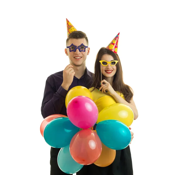 Homosexuell ung kille med en tjej, hålla nära pappersglasögon och massor av färgade luftballong — Stockfoto