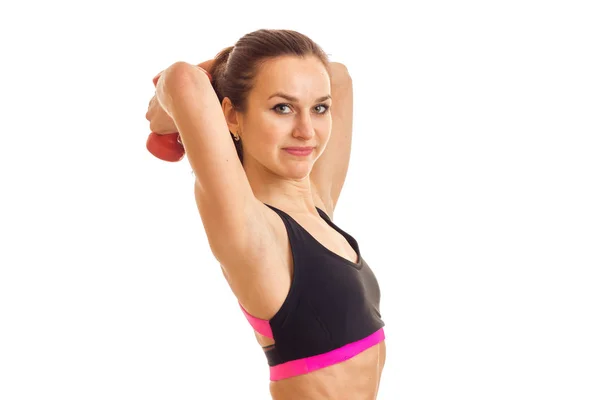 A young athletic girl in black top raised the dumbbells behind your head — Stock Photo, Image