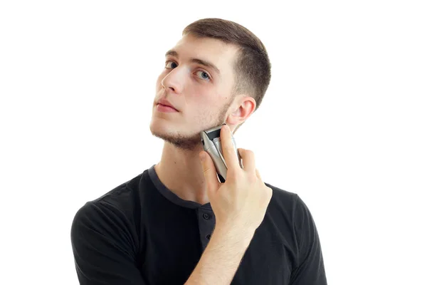 Joven serio chico en el negro camisa afeita su barba — Foto de Stock