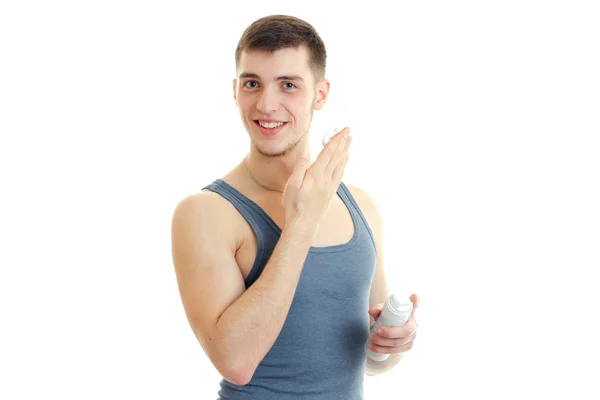 Young handsome guy holding a shaving foam and smiling — Stock Photo, Image