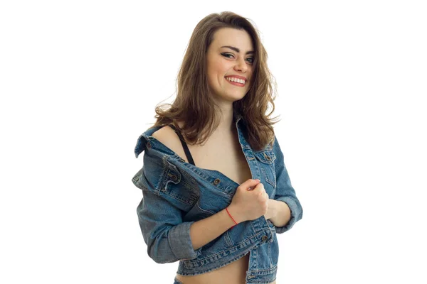 Uma jovem encantadora em jeans jaqueta olha para a câmera e sorrindo — Fotografia de Stock