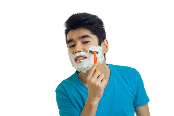 Joven con espuma en la cara afeita su barba máquina de primer plano —  Fotos de Stock