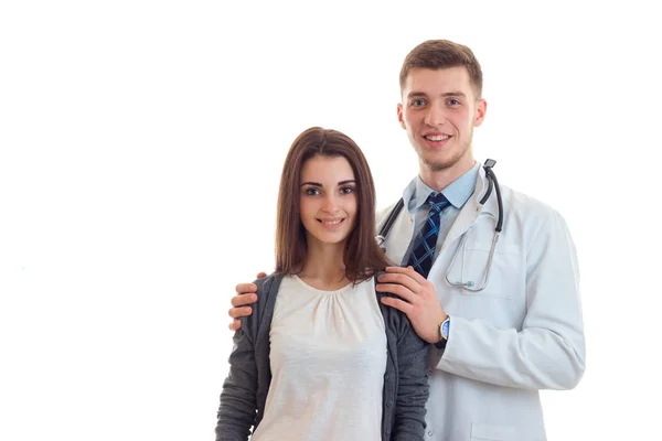 Hermosa joven de pie junto a un médico y sonriendo — Foto de Stock