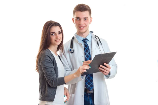 Fiatal mosolygó orvos visel egy ruhát, és egy tabletta a kezében áll, mellette egy szép lány — Stock Fotó