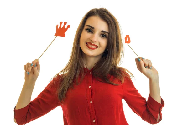 Веселая красивая девушка с красной помадой держит губки и бумагу Корона и улыбаясь — стоковое фото