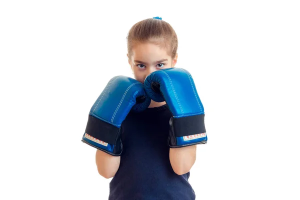 어린 소녀 그녀의 얼굴을 덮고 큰 권투 장갑의 손에 입고 — 스톡 사진